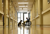 Photograph of a boy in a wheelchair and a dog at the end of a hallway.