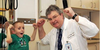 Photograph of a young boy and his doctor flexing their biceps. 