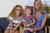 Photo of a mother and two girls in a clinic waiting room