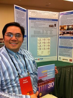 Ryan Inawat poses in front his poster he presented at the conference, holding up a book from Pacific Rim 2014 Conference titled "Learn from yesterday, live for today, envision tomorrow"